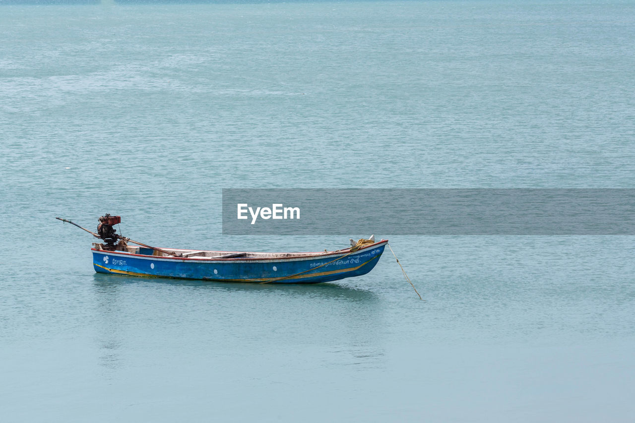 BOAT MOORED IN SEA