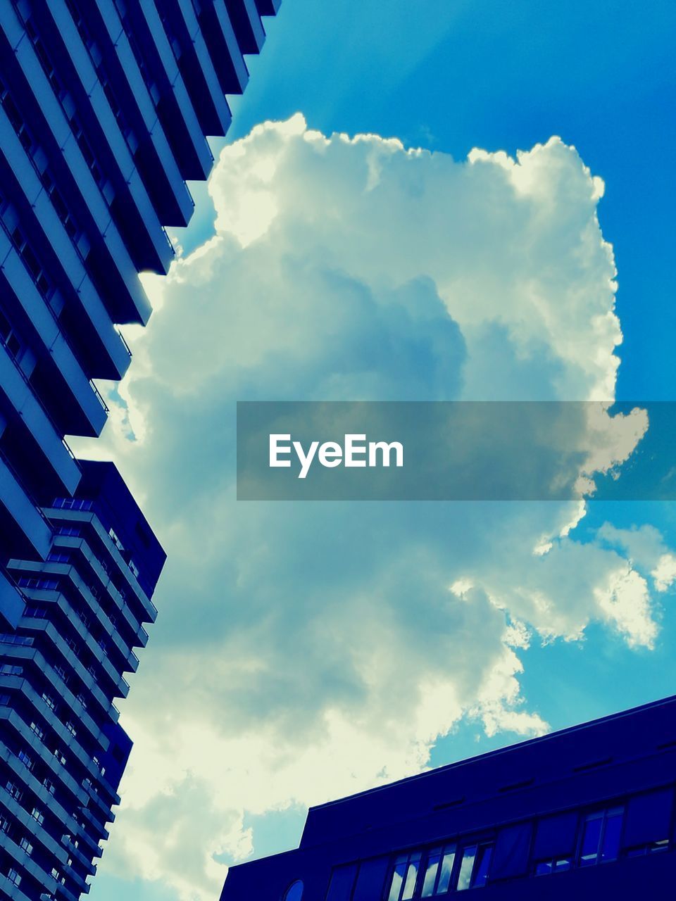 LOW ANGLE VIEW OF BUILDINGS AGAINST CLOUDY SKY