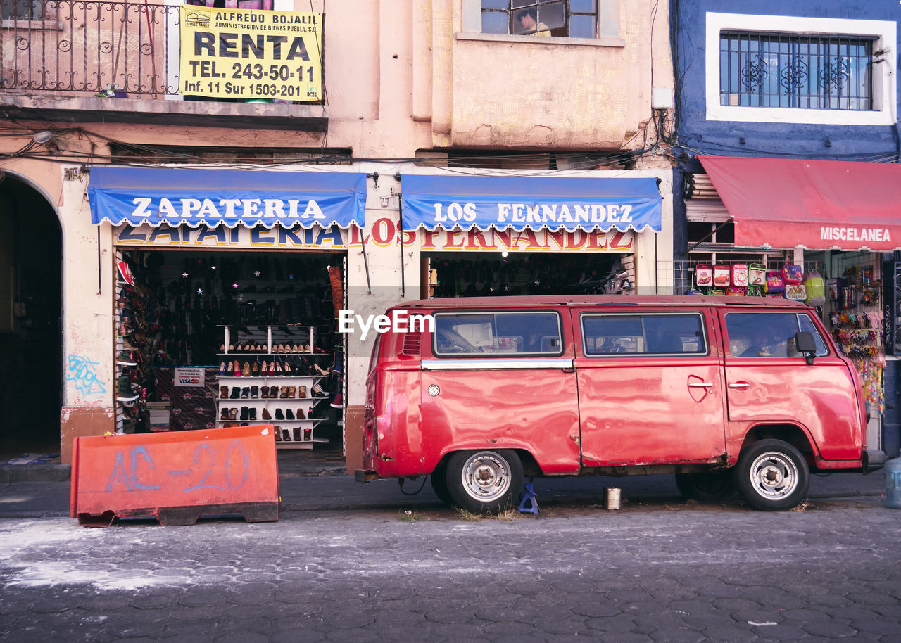 VINTAGE CAR ON STREET AGAINST BUILDINGS