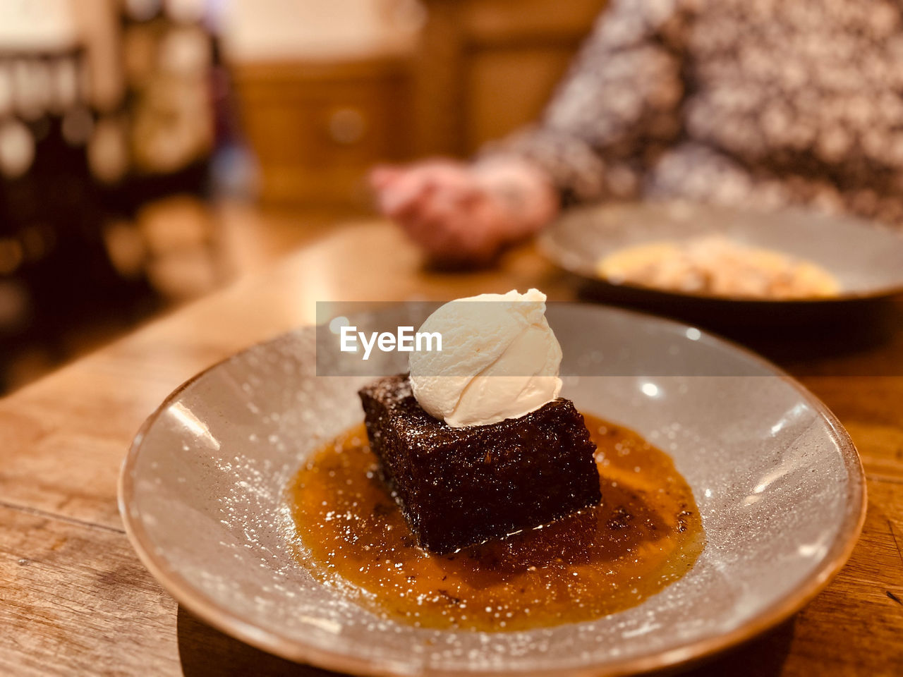 food and drink, food, sweet food, dessert, sweet, sweetness, indoors, freshness, dish, table, baked, plate, meal, cake, chocolate, focus on foreground, breakfast, temptation, one person, frozen, wood, adult, close-up, selective focus, frozen food