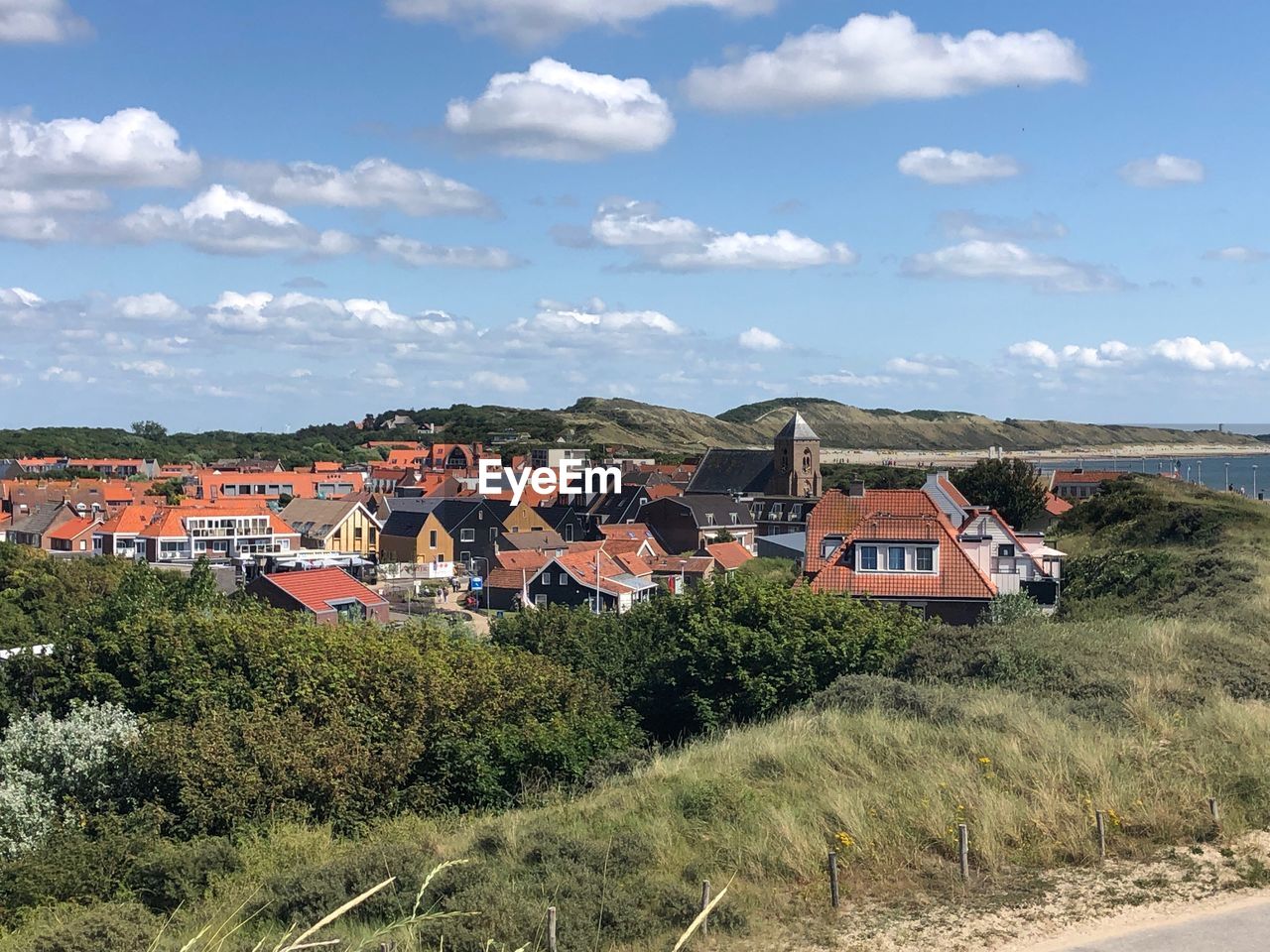 HOUSES ON FIELD AGAINST SKY IN CITY