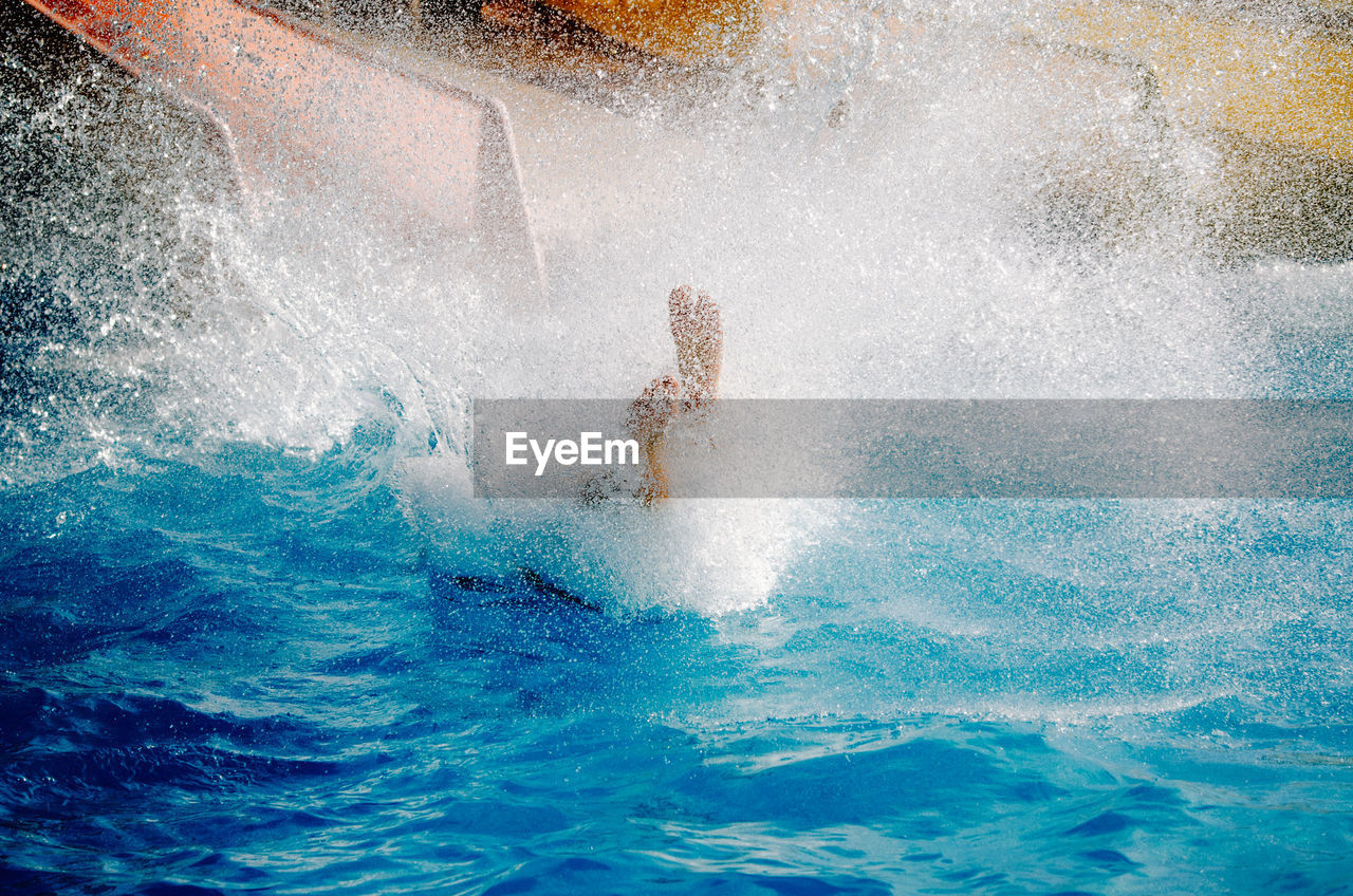 High angle view of man splashing water in pool at aqua paradise ltd water park