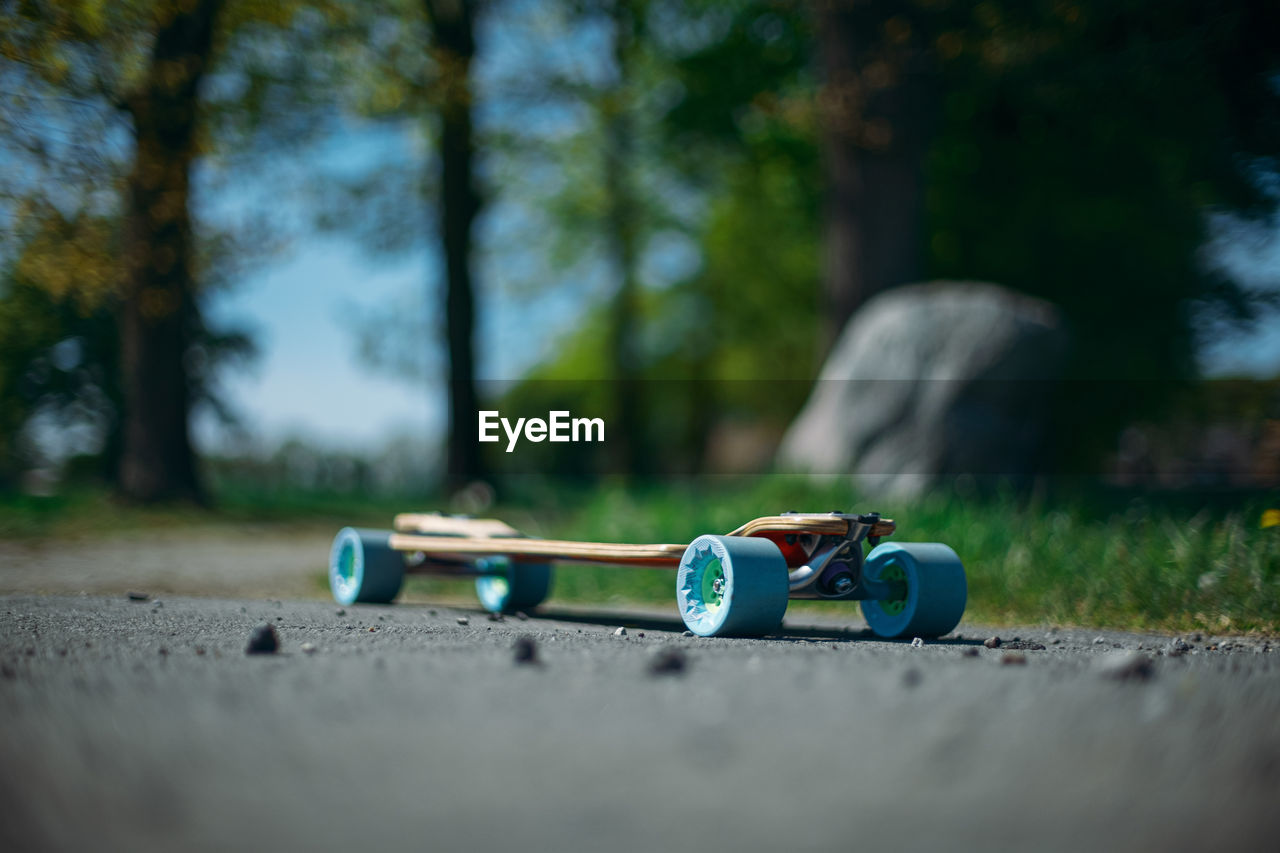 Low angle view of skateboard on street against trees