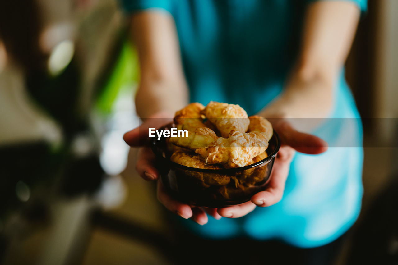 CLOSE-UP OF HAND HOLDING BREAD