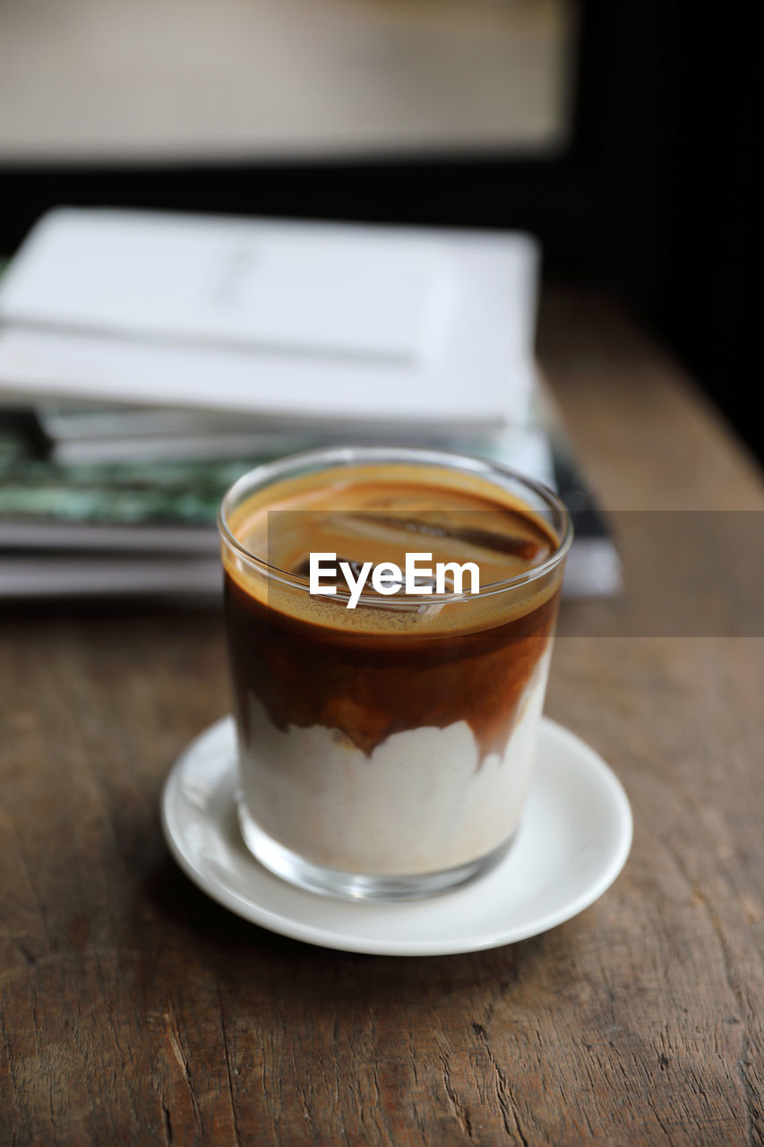 CLOSE-UP OF COFFEE CUP ON WOODEN TABLE