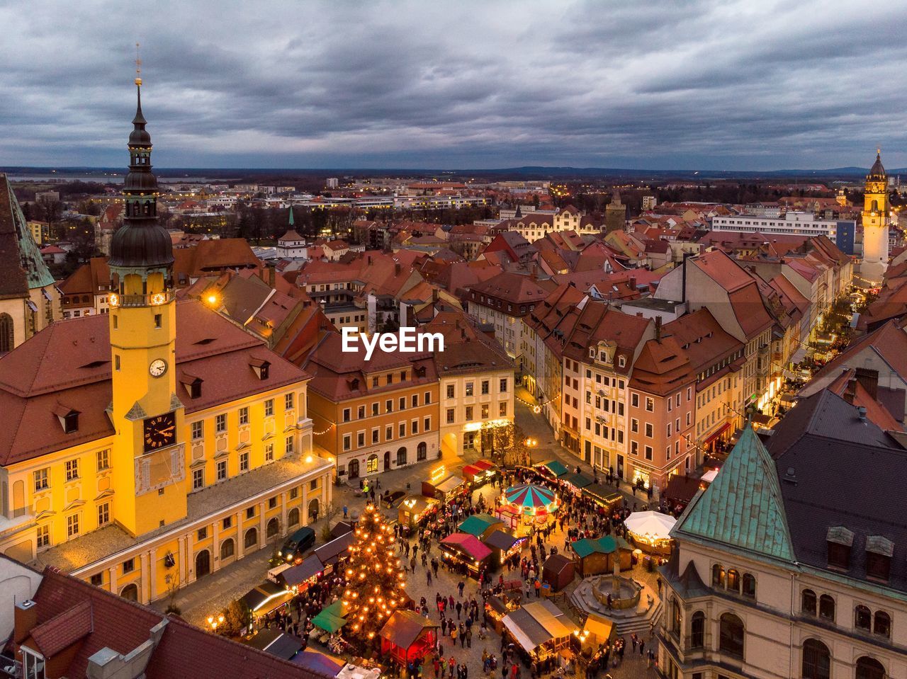 High angle view of people walking by illuminated buildings in city