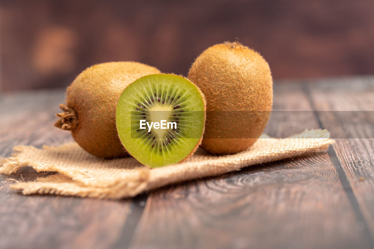 A half of kiwi on the wooden table with blurred background