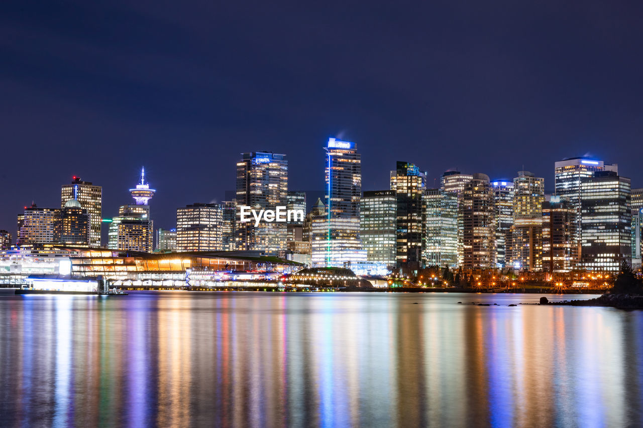 Illuminated buildings against sky at night