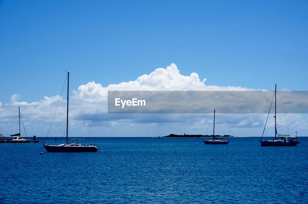 Boats on blue sea against sky