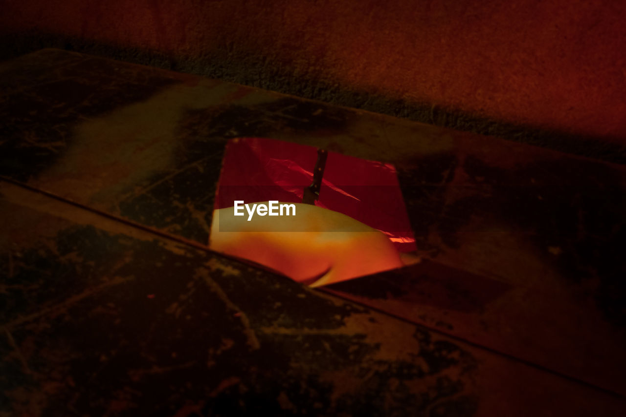 HIGH ANGLE VIEW OF PAPER FLAG ON ILLUMINATED WALL