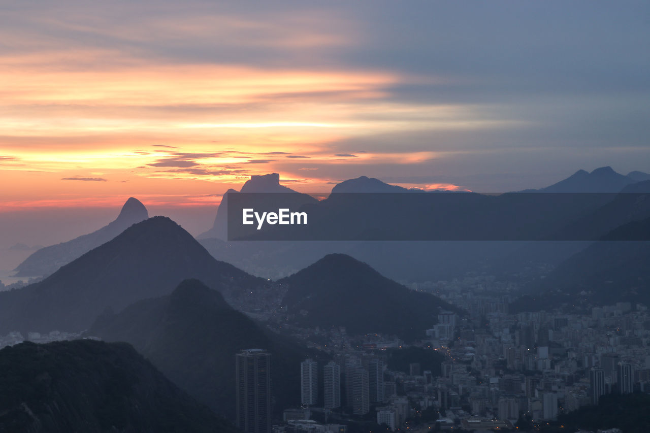 PANORAMIC SHOT OF BUILDINGS AGAINST SKY DURING SUNSET