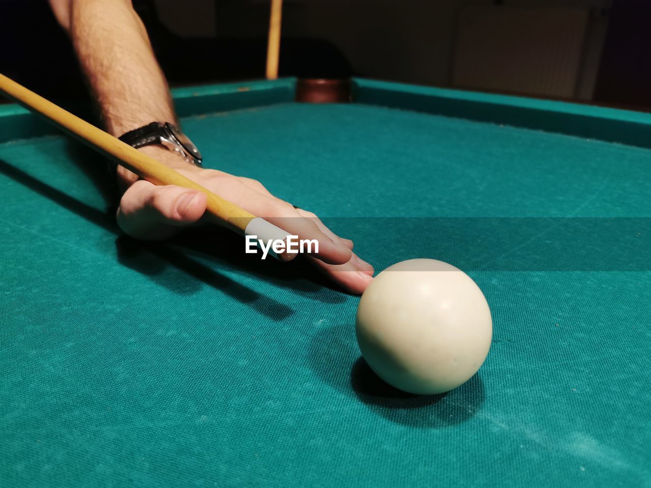 Person playing with ball on table, snooker game