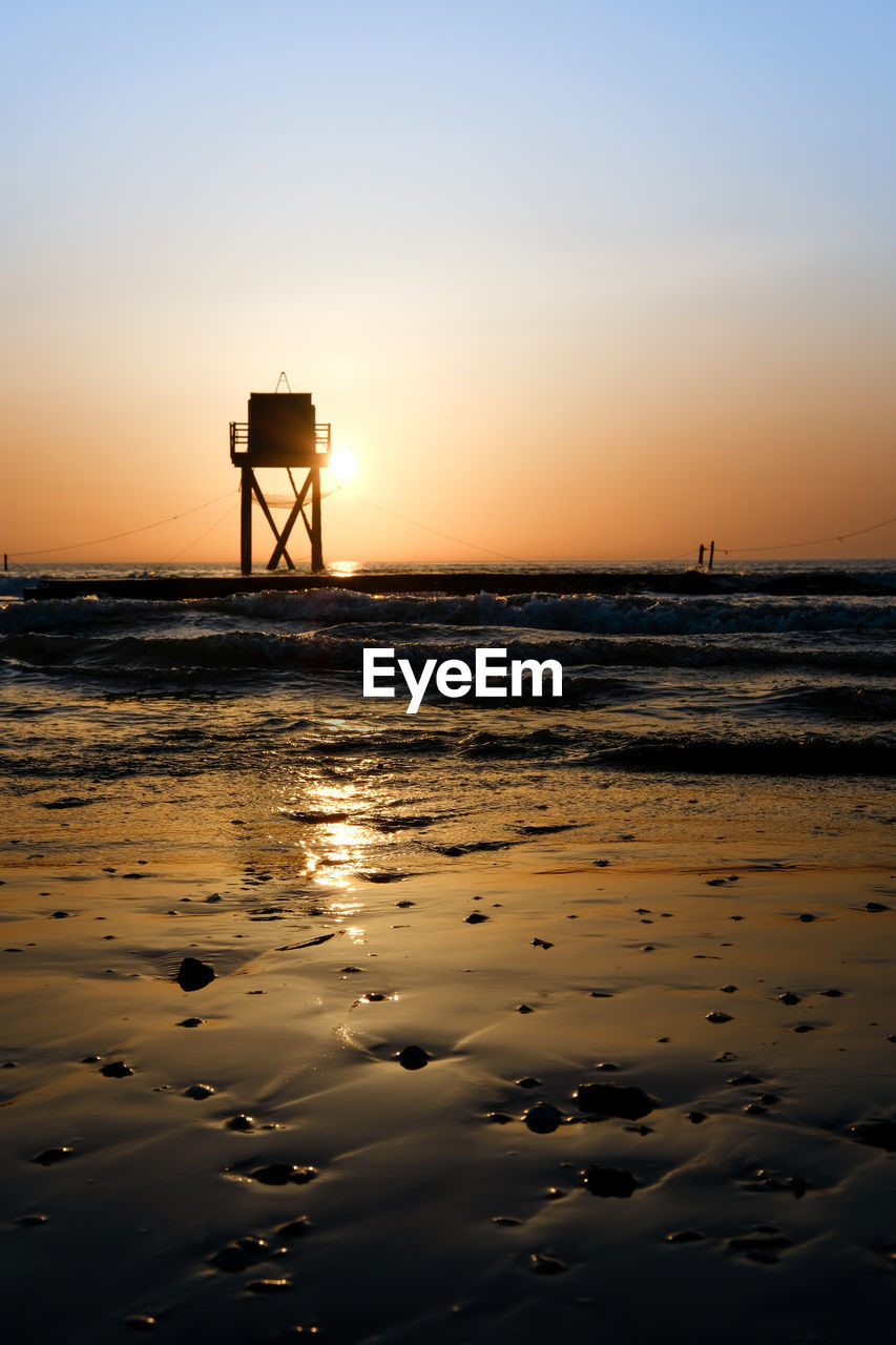 SILHOUETTE TOWER ON BEACH DURING SUNSET