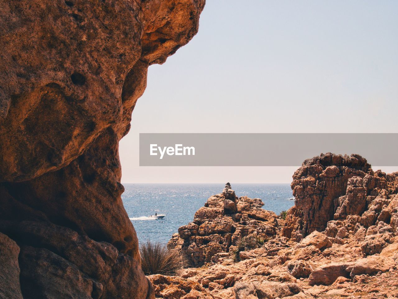 Scenic view of sea against clear sky from rocky shore