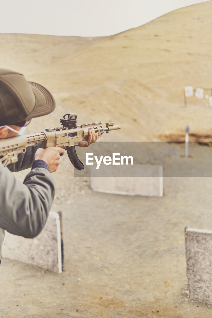 Men practicing shooting with a assault rifle at target. selective focus