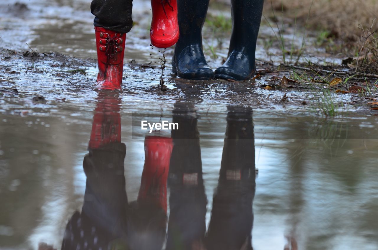 Low section of people standing in puddle