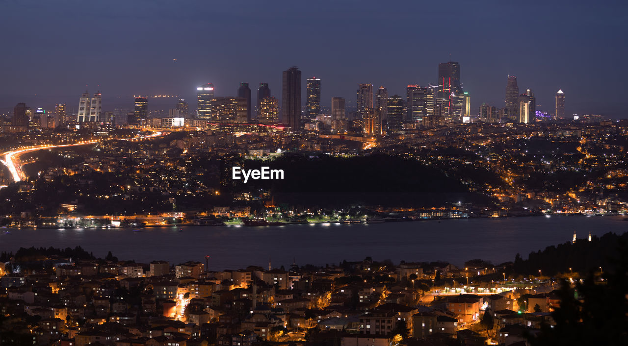 ILLUMINATED BUILDINGS IN CITY AT NIGHT