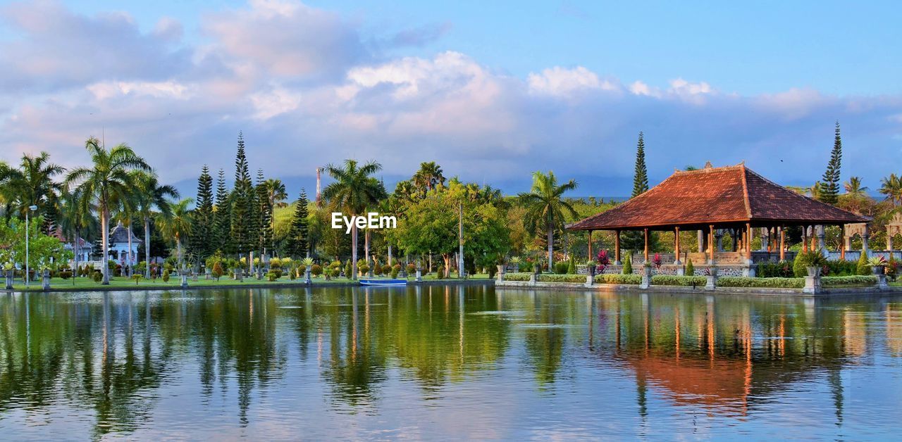 PANORAMIC VIEW OF PALM TREES AND LAKE AGAINST SKY
