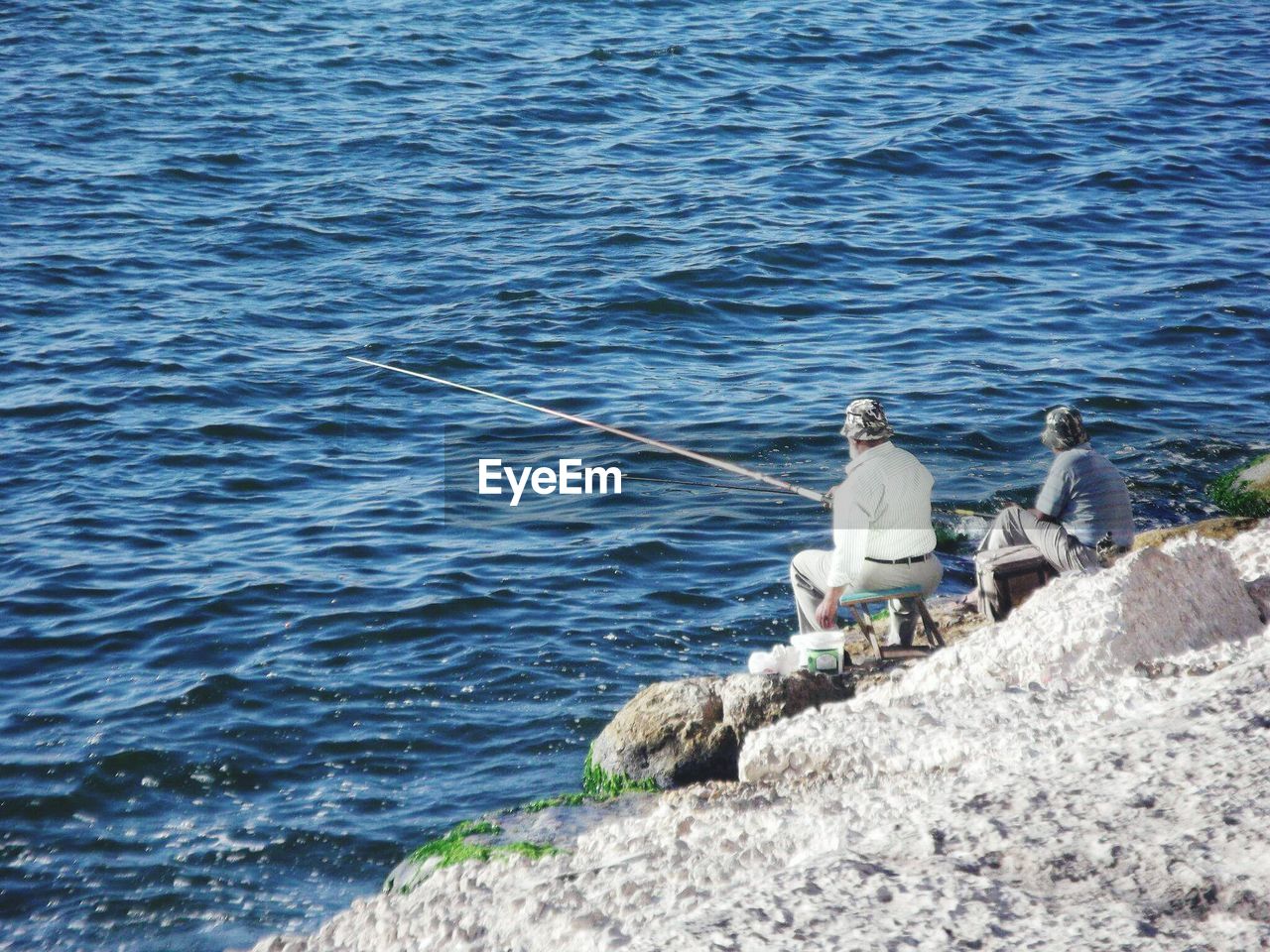 High angle view of men fishing at shore