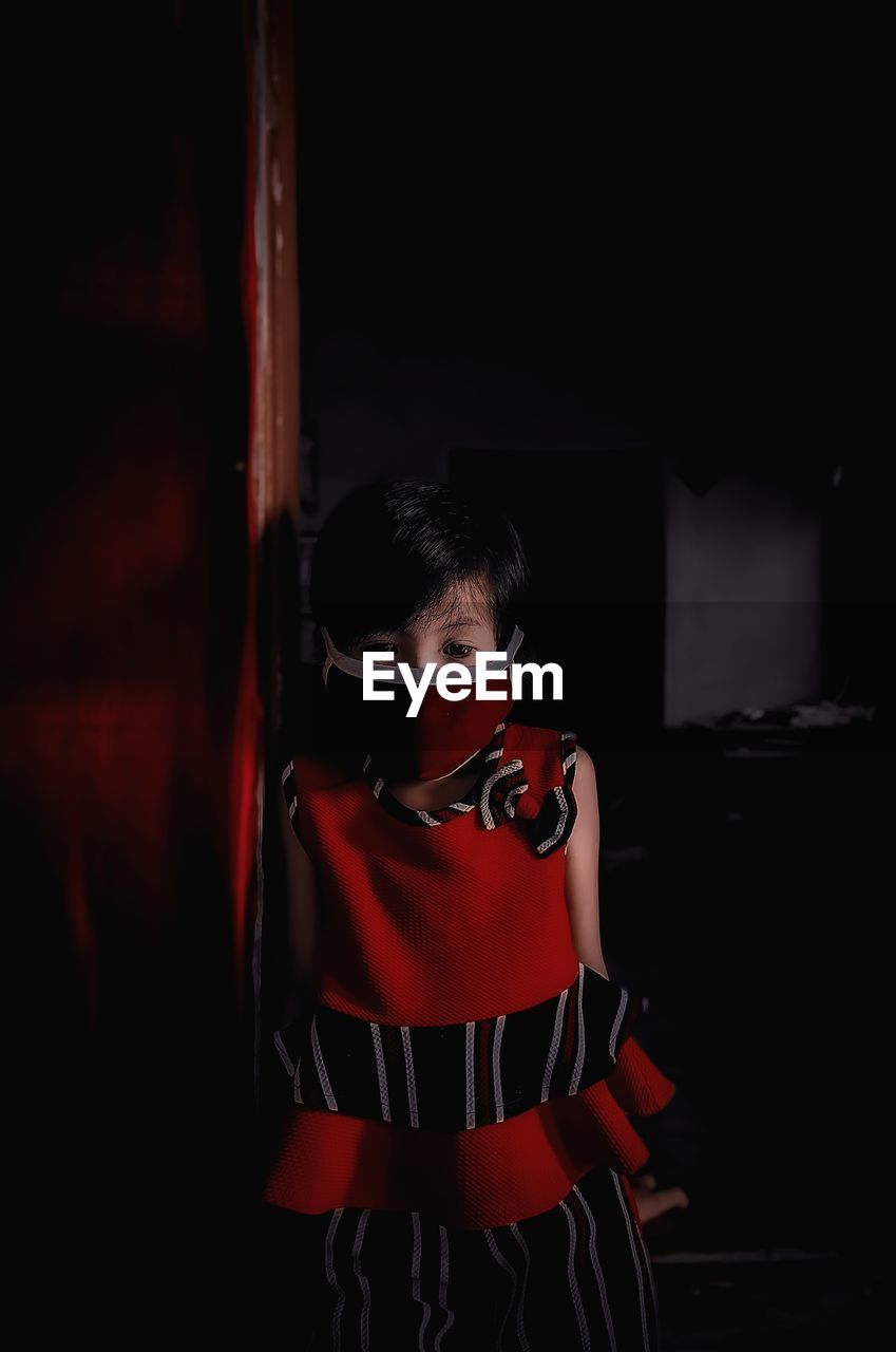 Girl wearing mask while standing at home