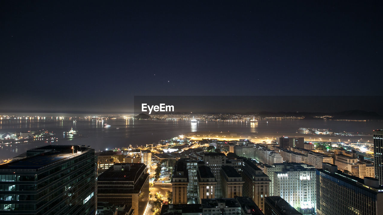 High angle view of illuminated buildings against sky at night