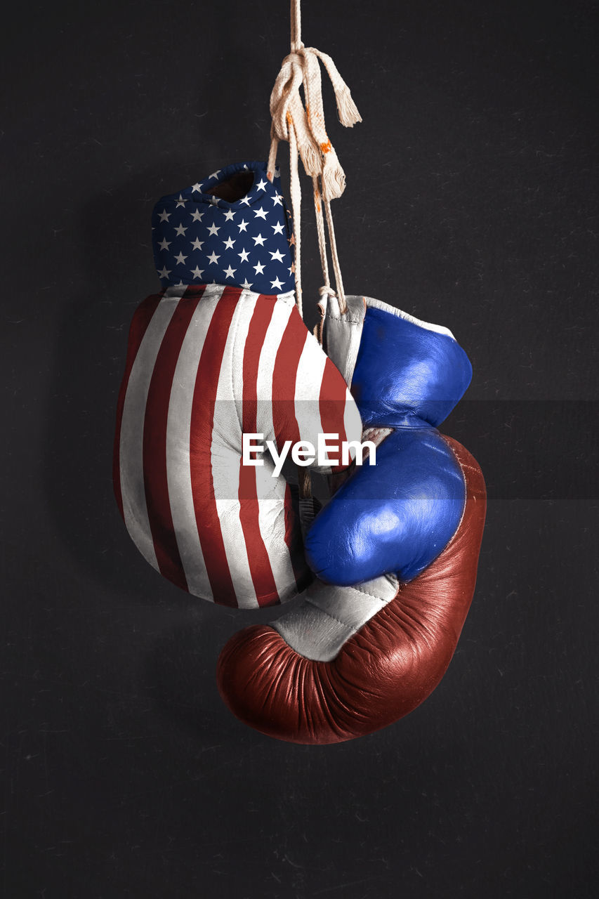 Close-up of boxing gloves hanging against wall