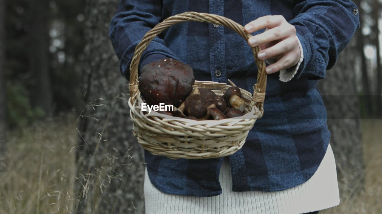 MIDSECTION OF MAN HOLDING ICE CREAM IN BASKET