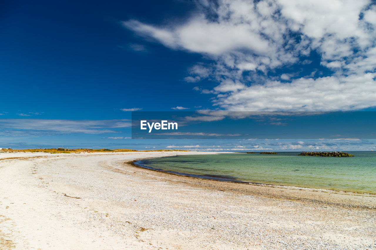 Scenic view of beach against blue sky