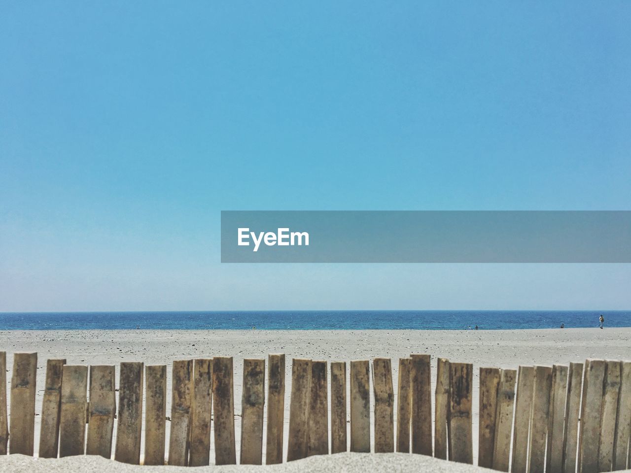 Scenic view of beach against clear blue sky