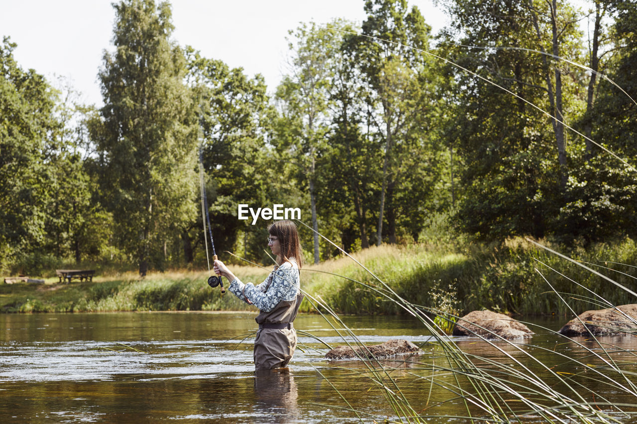 Woman fishing in lake