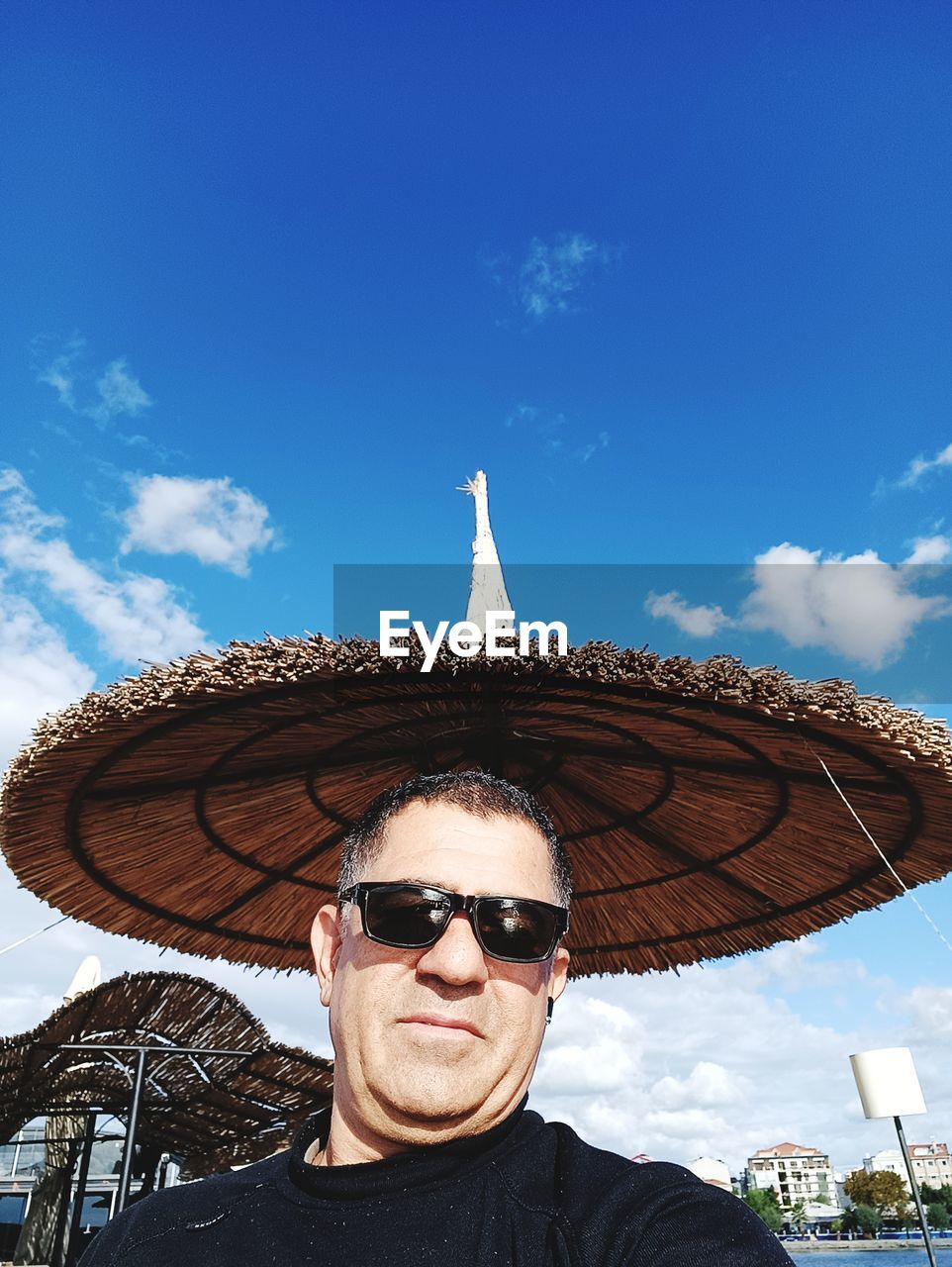 sky, sunglasses, fashion, one person, portrait, adult, cloud, glasses, blue, men, sombrero, nature, front view, hat, travel, clothing, travel destinations, looking at camera, day, outdoors, headshot, smiling, young adult, person, tourism, vacation, trip, sun hat, happiness, leisure activity, holiday, architecture, fashion accessory, summer