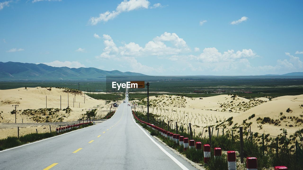 PANORAMIC VIEW OF ROAD LEADING TOWARDS MOUNTAINS