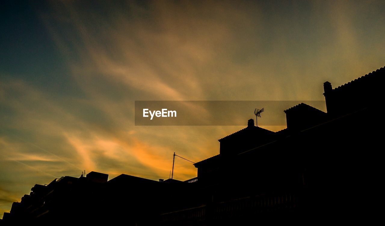 Low angle view of building against sky at sunset