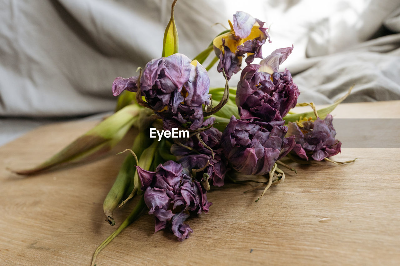 Bouquet of purple tulips laying on a wooden table