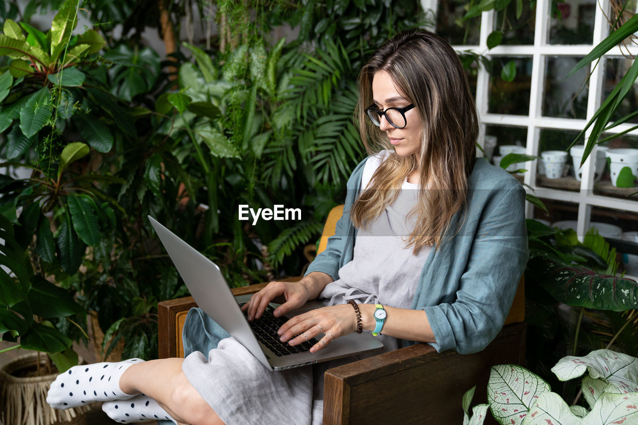 Woman using laptop while sitting on chair