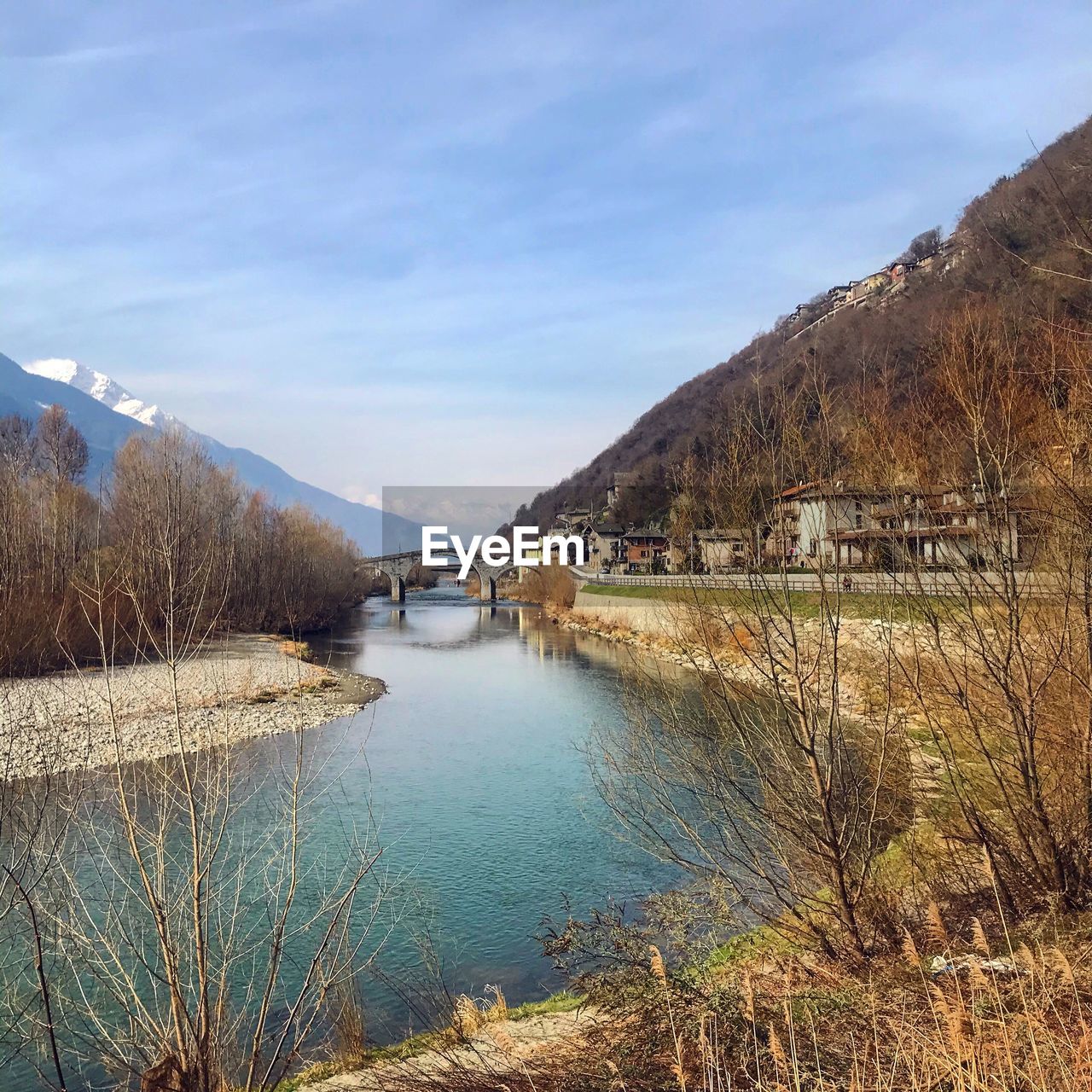 Scenic view of river by mountains against sky