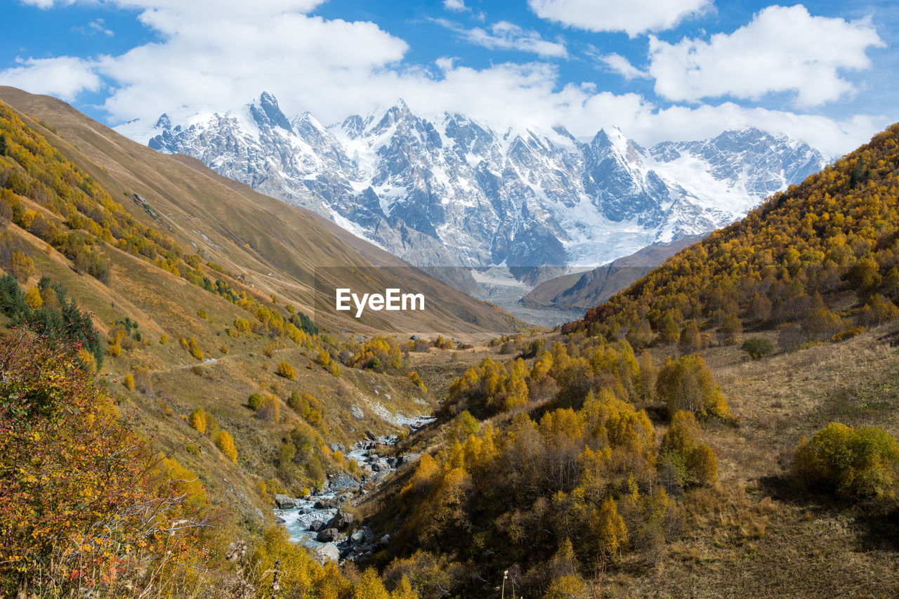 Scenic view of mountains against cloudy sly