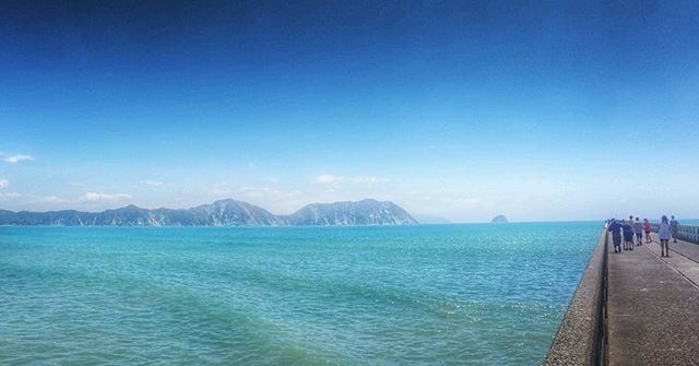 SCENIC VIEW OF SEA WITH MOUNTAIN IN BACKGROUND