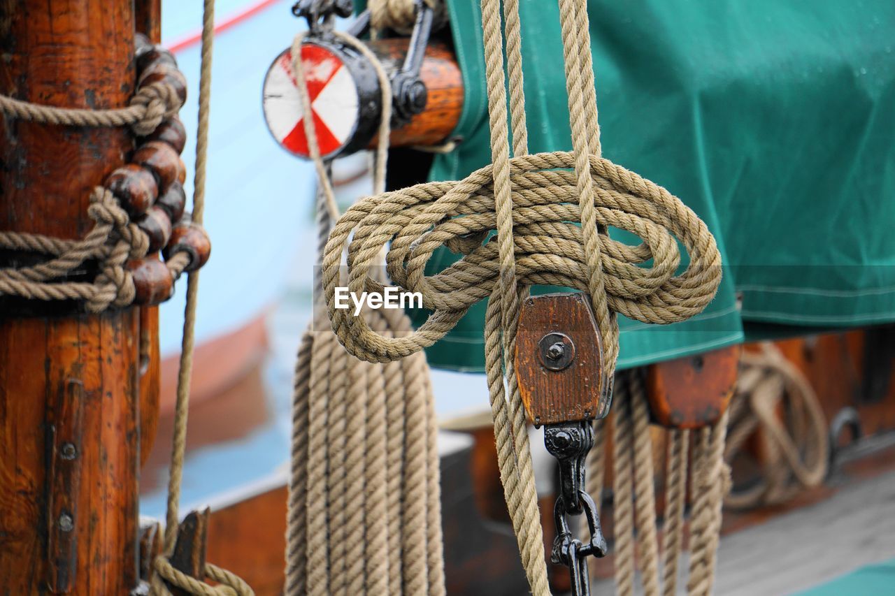 CLOSE-UP OF ROPE TIED TO POST ON WOODEN POSTS