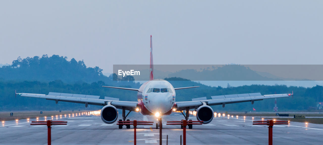 Airplane taking off on runway against sky