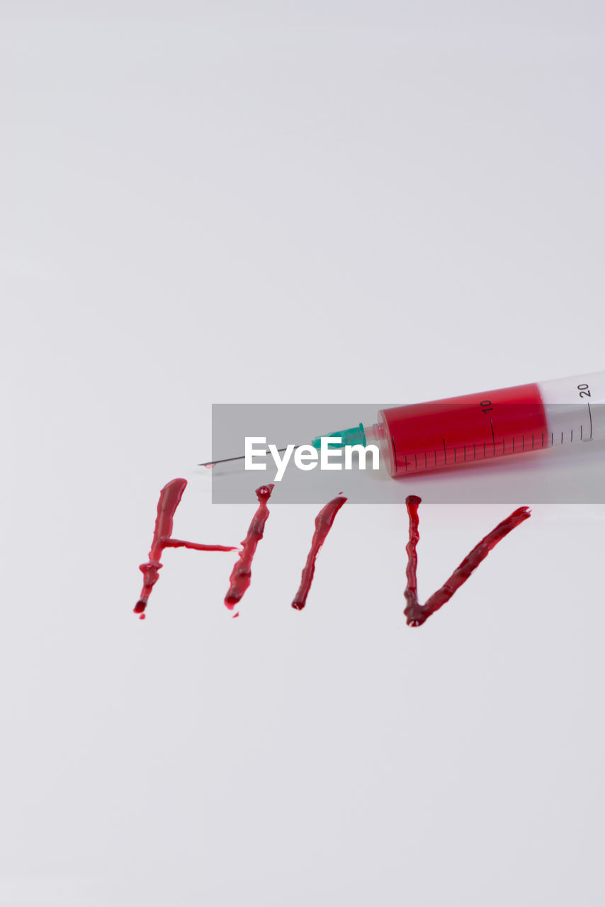 Syringe with hiv text on white background