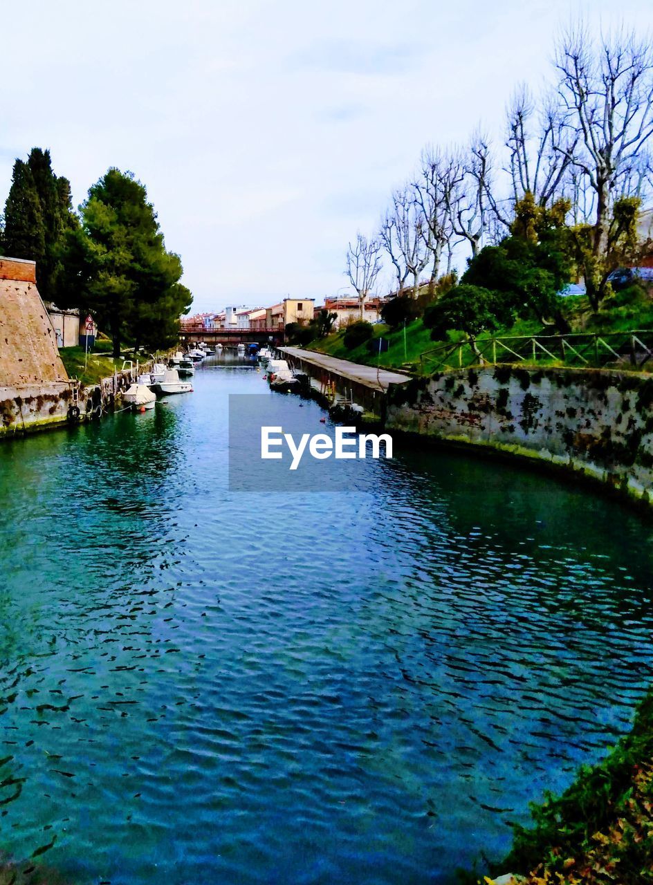 RIVER AMIDST BUILDINGS AGAINST SKY