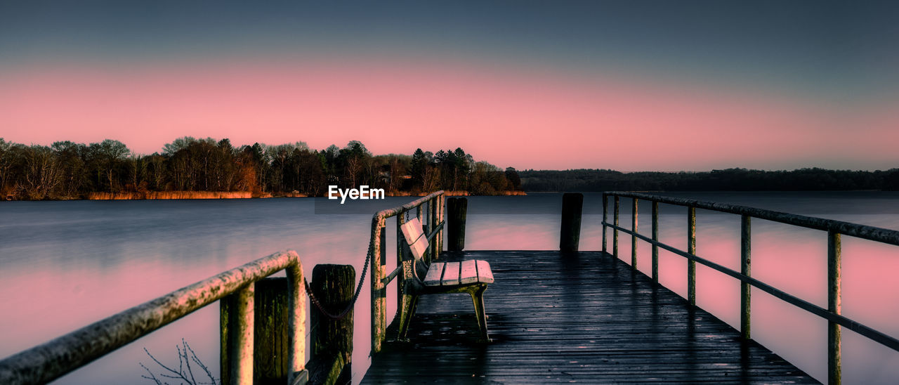 pier over sea against sky during sunset