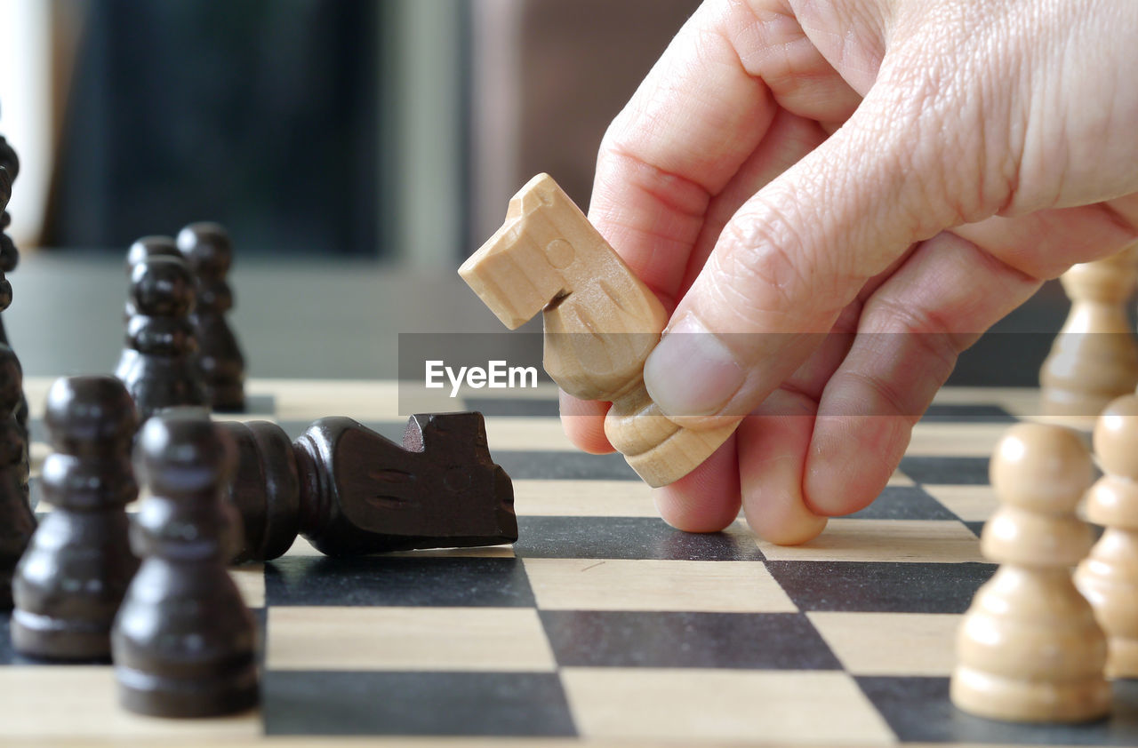 Cropped hand of person playing chess 