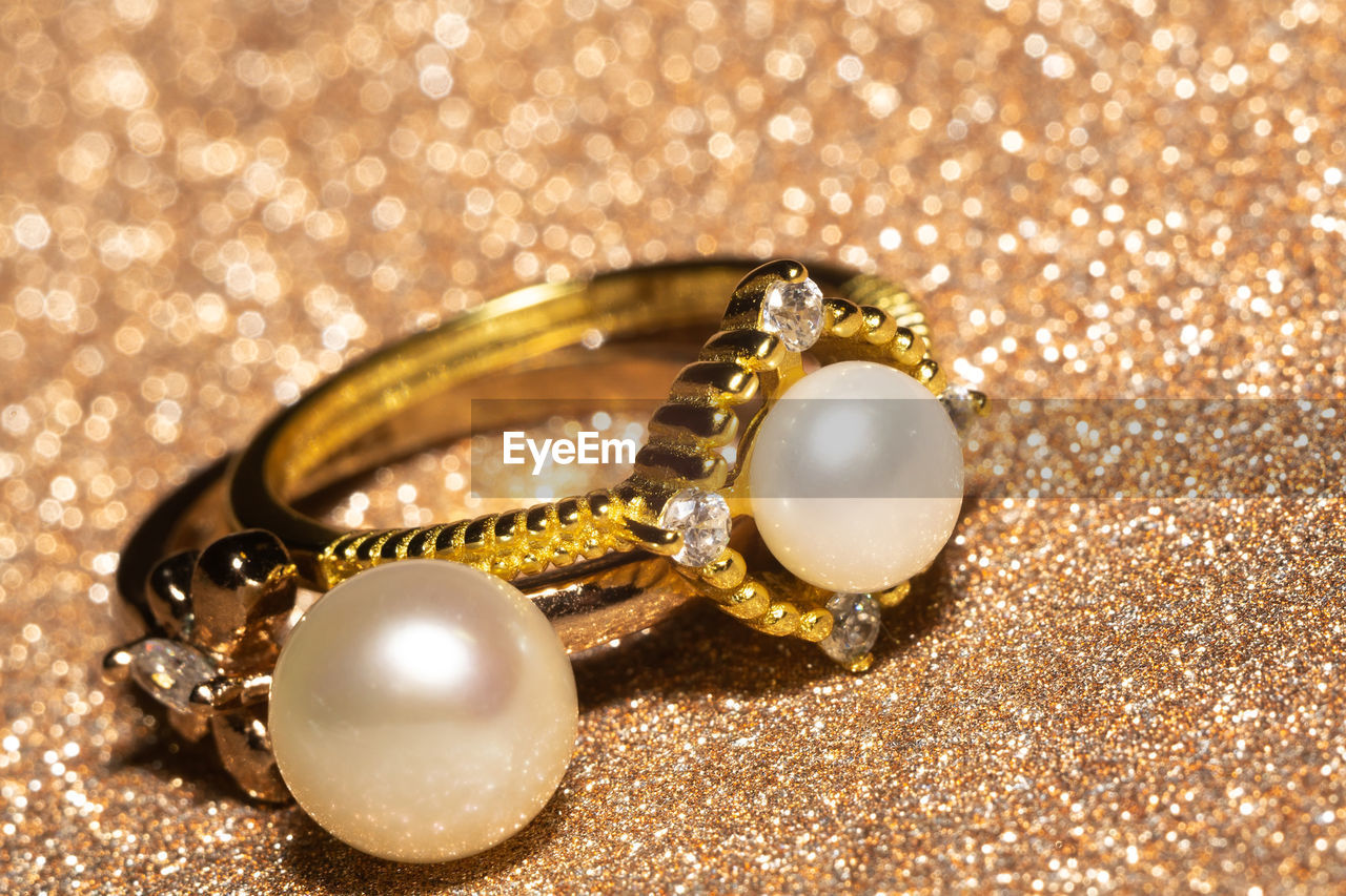 Fashion yellow gold ring decorated with natural white freshwater pearl, close up.