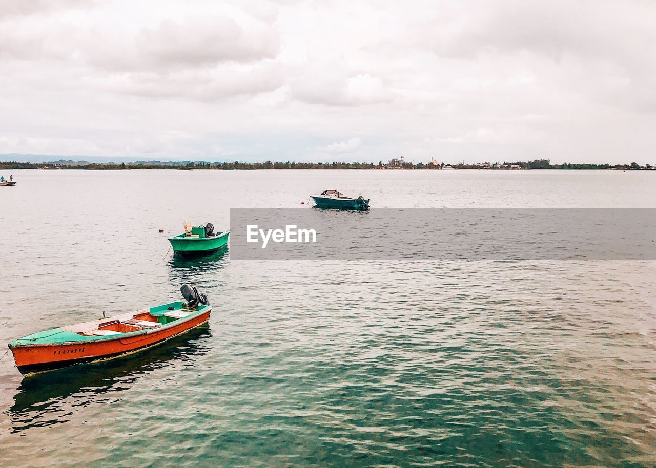 Boats moored on sea against sky