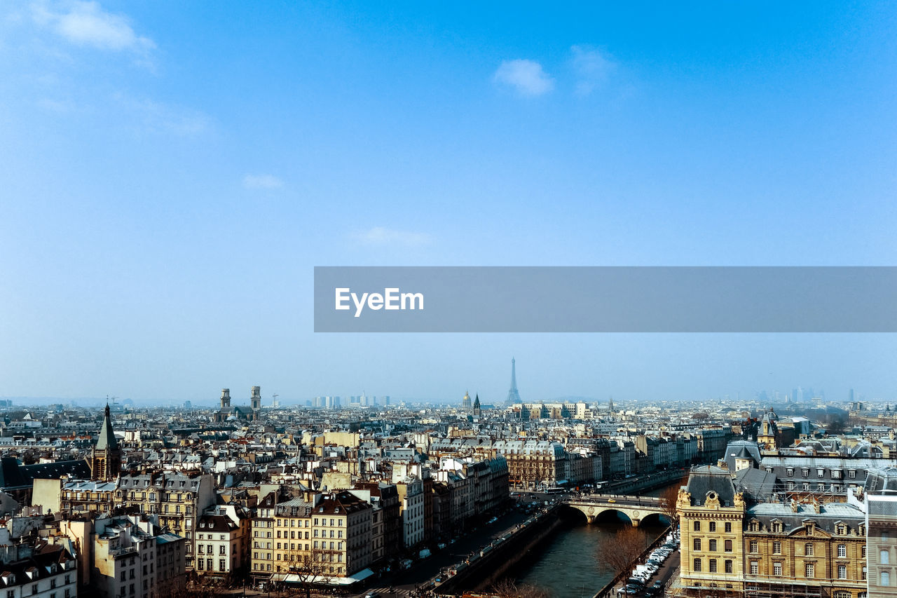 Distant view of eiffel tower against blue sky in city