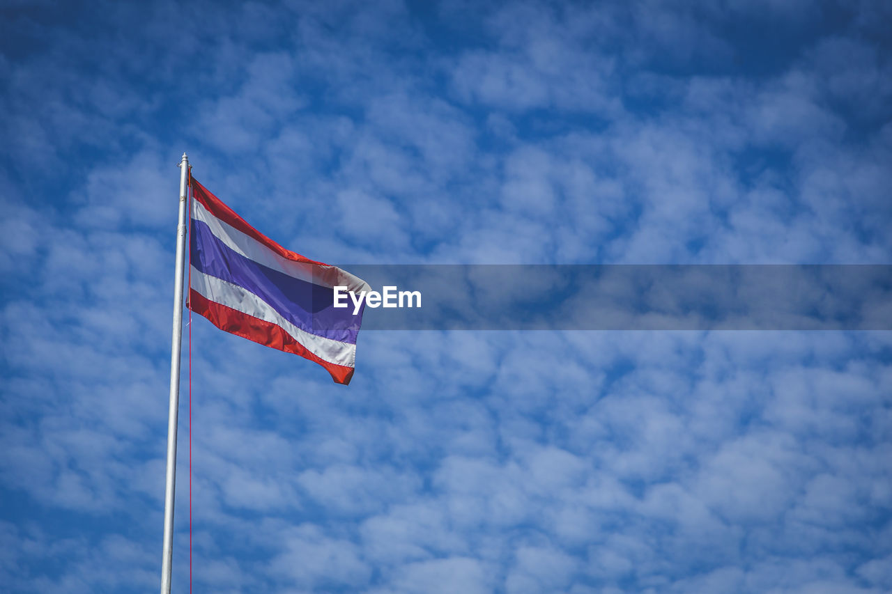 Low angle view of thailand flag waving against cloudy sky