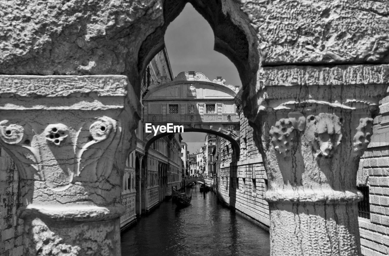 Bridge of sighs over canal amidst buildings