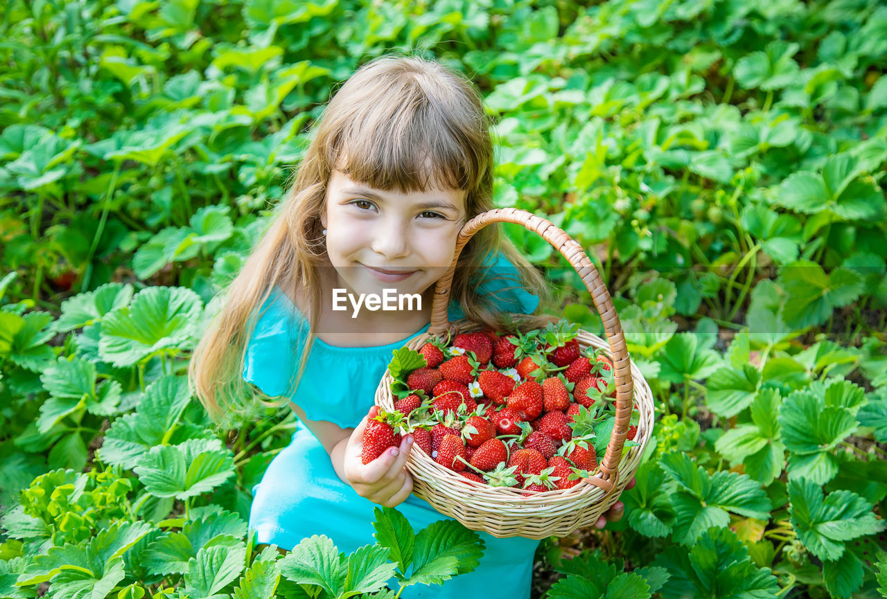 Portrait of young woman picking grapes